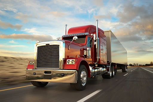 Commercial truck driving on a Florida highway with the sun shining, symbolizing the need for reliable insurance coverage.